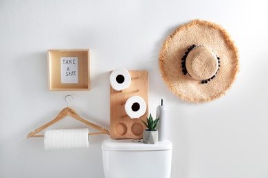 Decor elements, necessities and toilet bowl near white wall. Bathroom interior