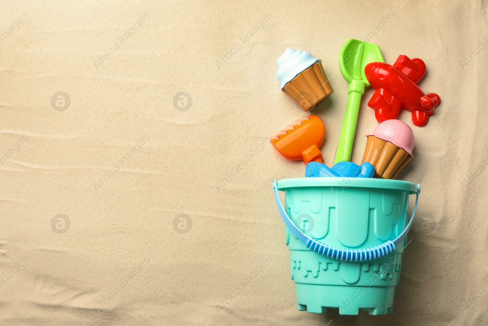 Photo of Flat lay composition with beach toys on sand. Space for text