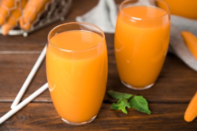 Photo of Freshly made carrot juice on wooden table