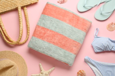Photo of Towel and different beach accessories on pink background, flat lay