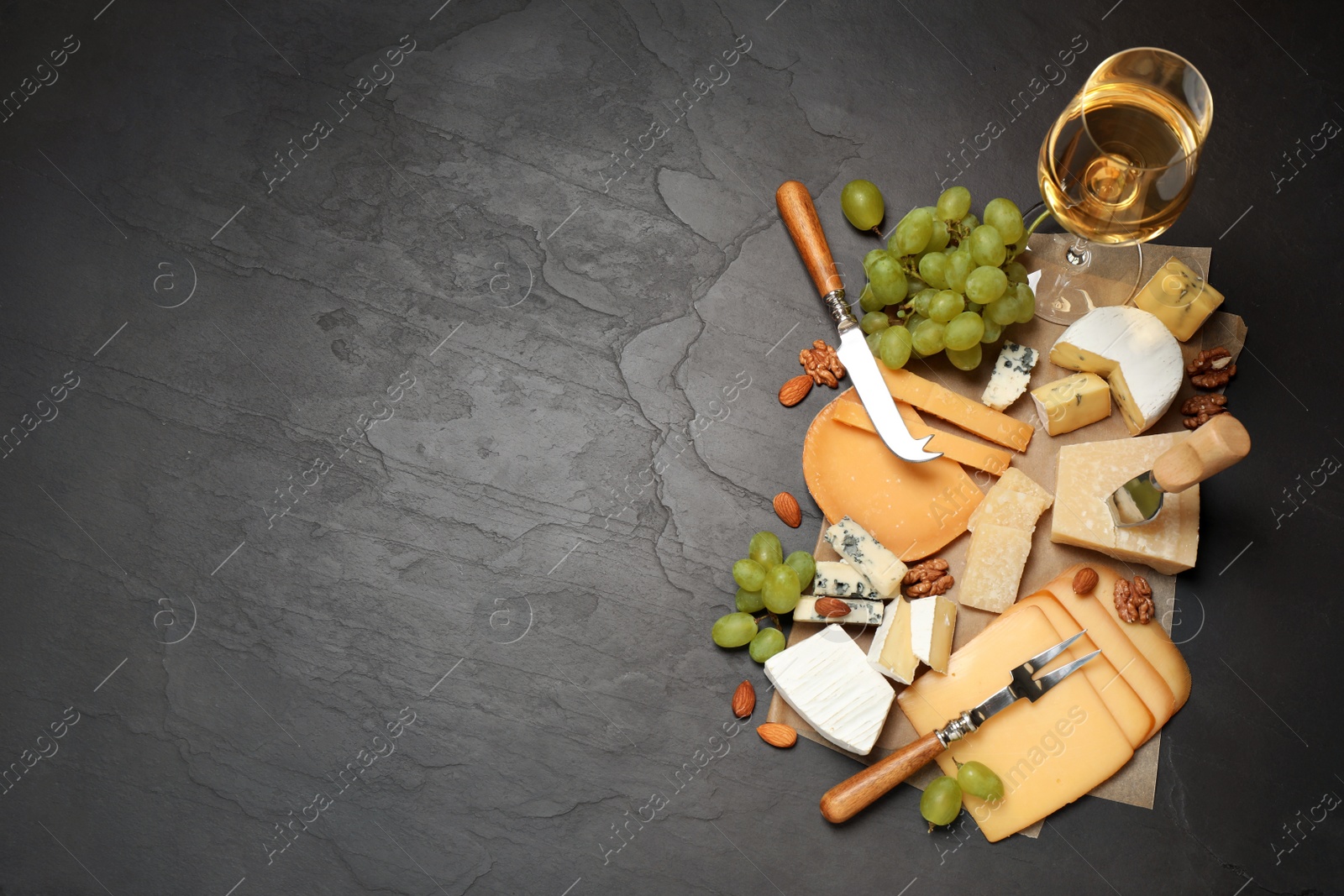 Photo of Flat lay composition with different sorts of cheese and knives on black table. Space for text