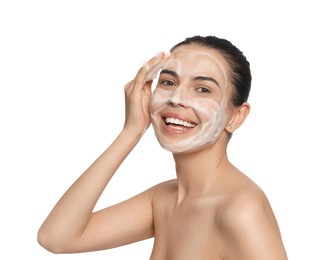 Happy young woman washing face with cosmetic product on white background