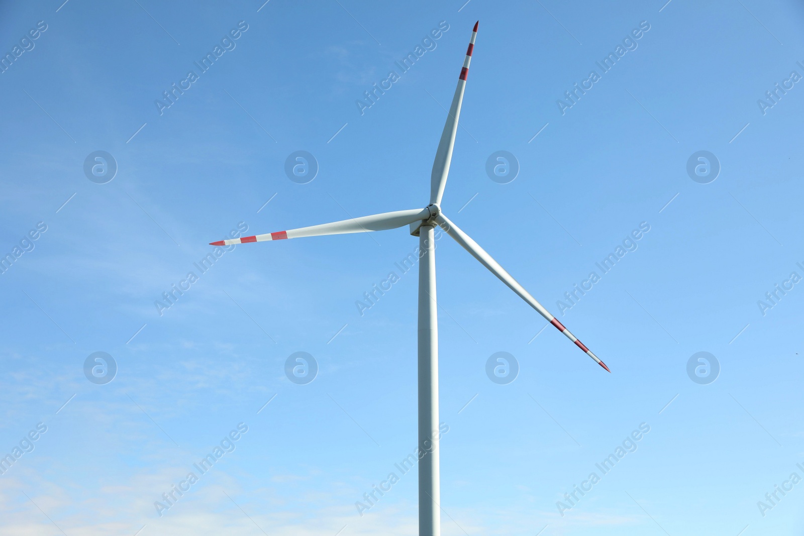 Photo of Modern wind turbine against blue sky. Alternative energy source