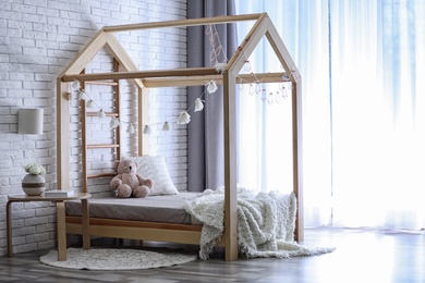 Photo of Stylish child room interior with cute wooden bed