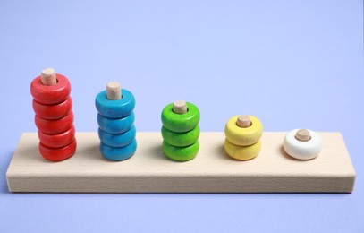 Photo of Stacking and counting game wooden pieces on violet background. Educational toy for motor skills development