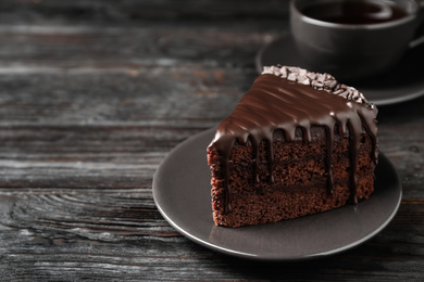 Photo of Delicious chocolate cake on black wooden table, space for text