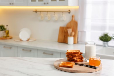 Breakfast served in kitchen. Crunchy toasts, honey and milk on white marble table. Space for text