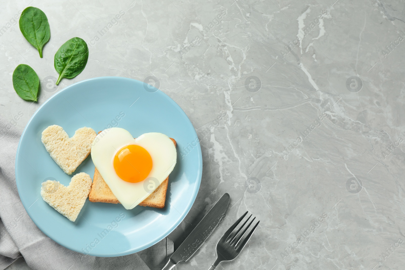 Photo of Romantic breakfast with heart shaped fried egg on served grey marble table, flat lay. Space for text