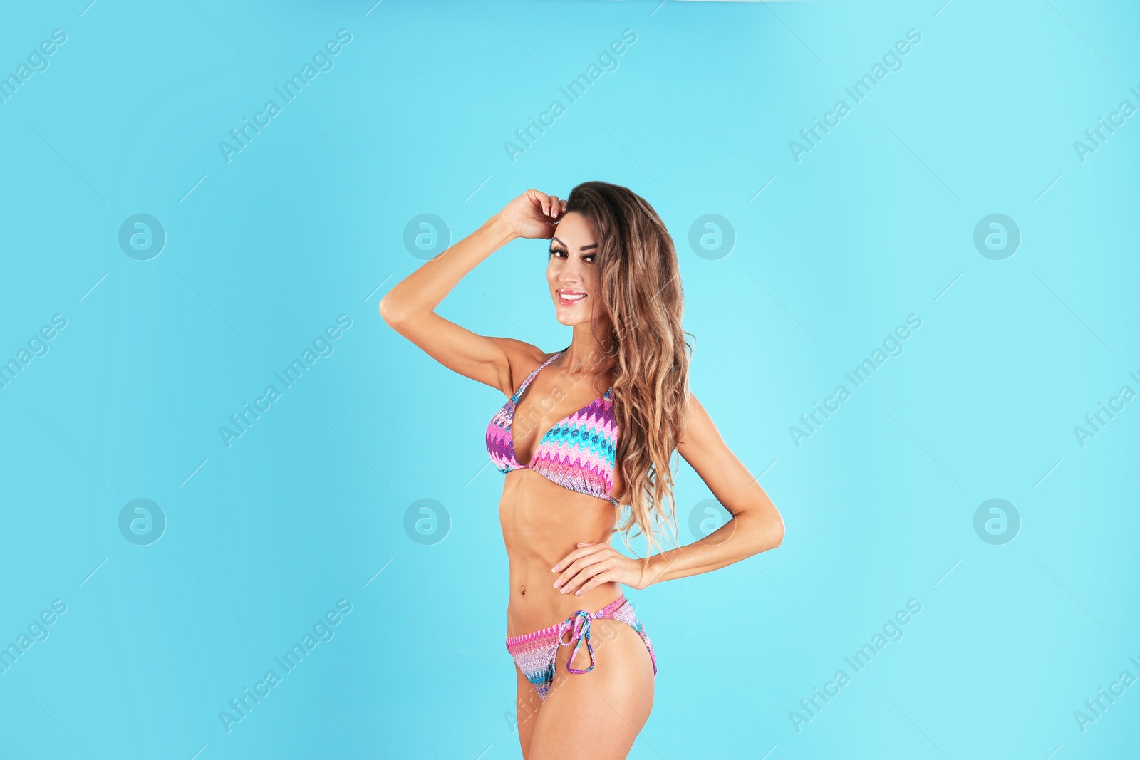 Photo of Pretty sexy woman with beautiful slim body in stylish bikini on color background