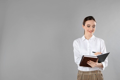 Portrait of young female teacher on grey background. Space for text