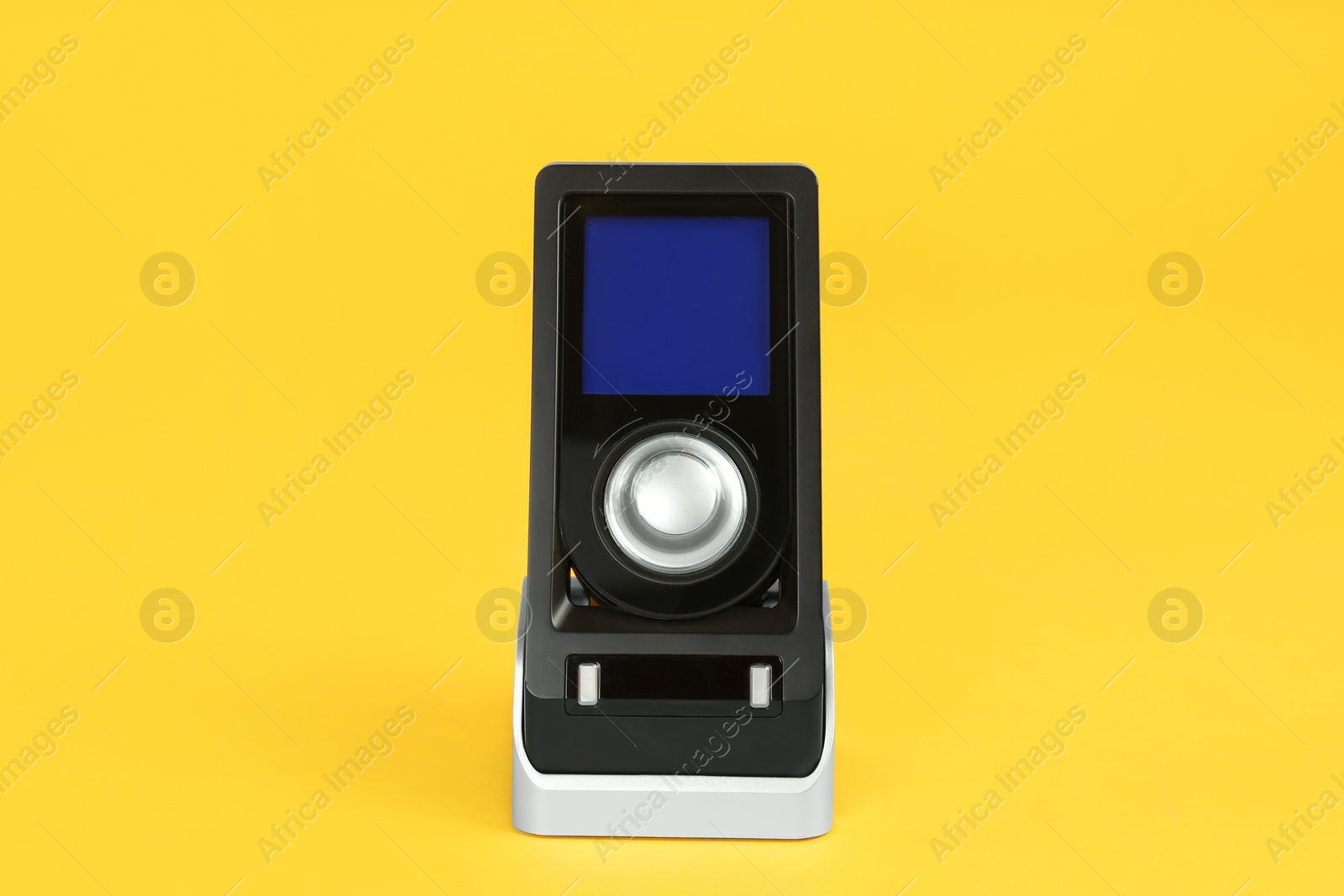 Photo of Modern remote for audio speakers on yellow background