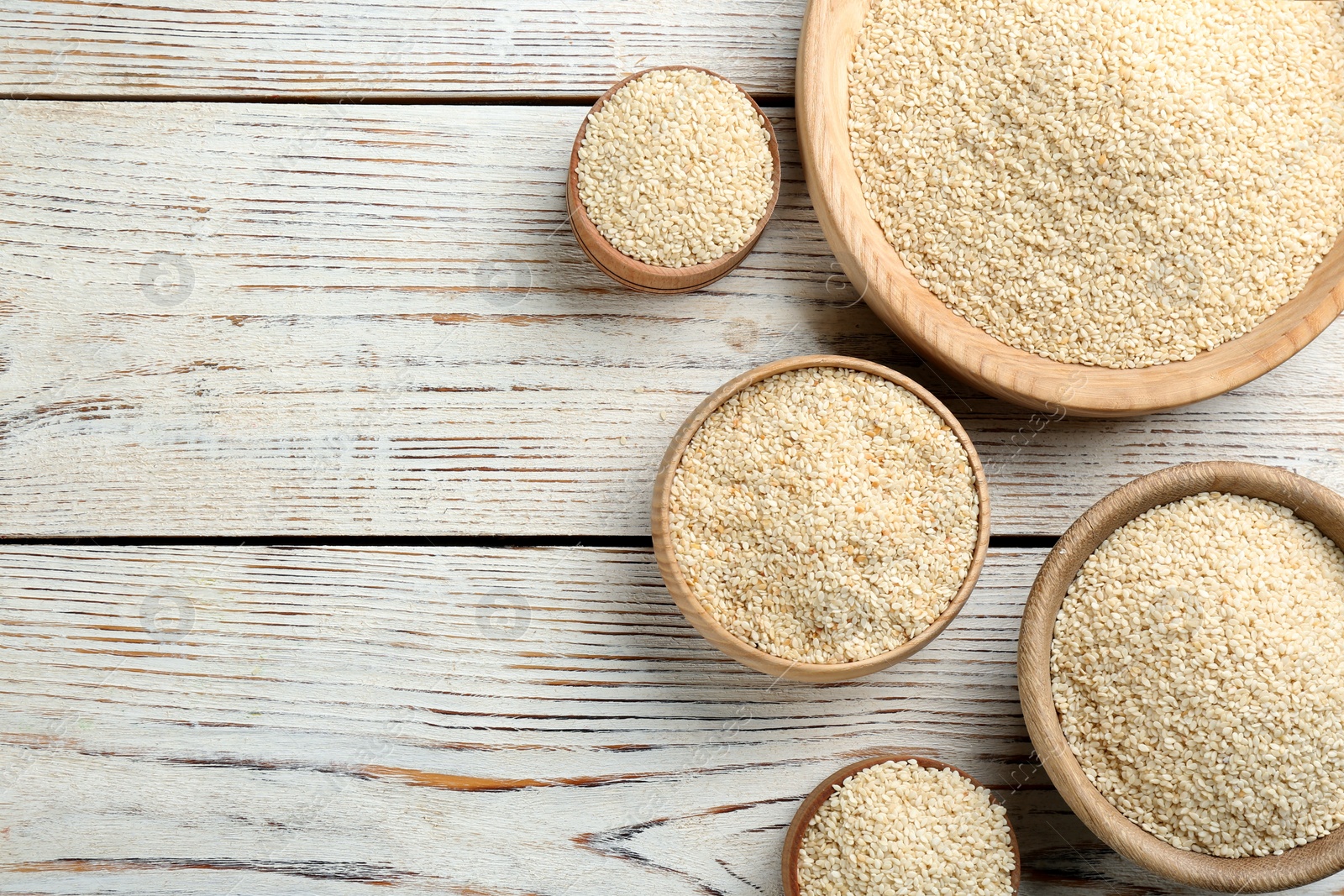 Photo of White sesame seeds on wooden table, flat lay. Space for text