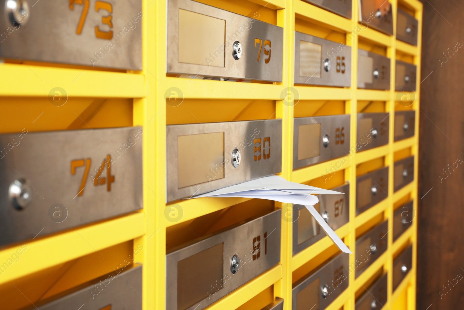 Photo of Metal mailboxes with receipts from post office indoors, closeup