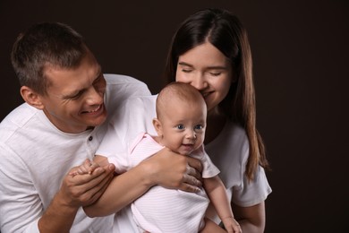 Happy family with little baby on dark background