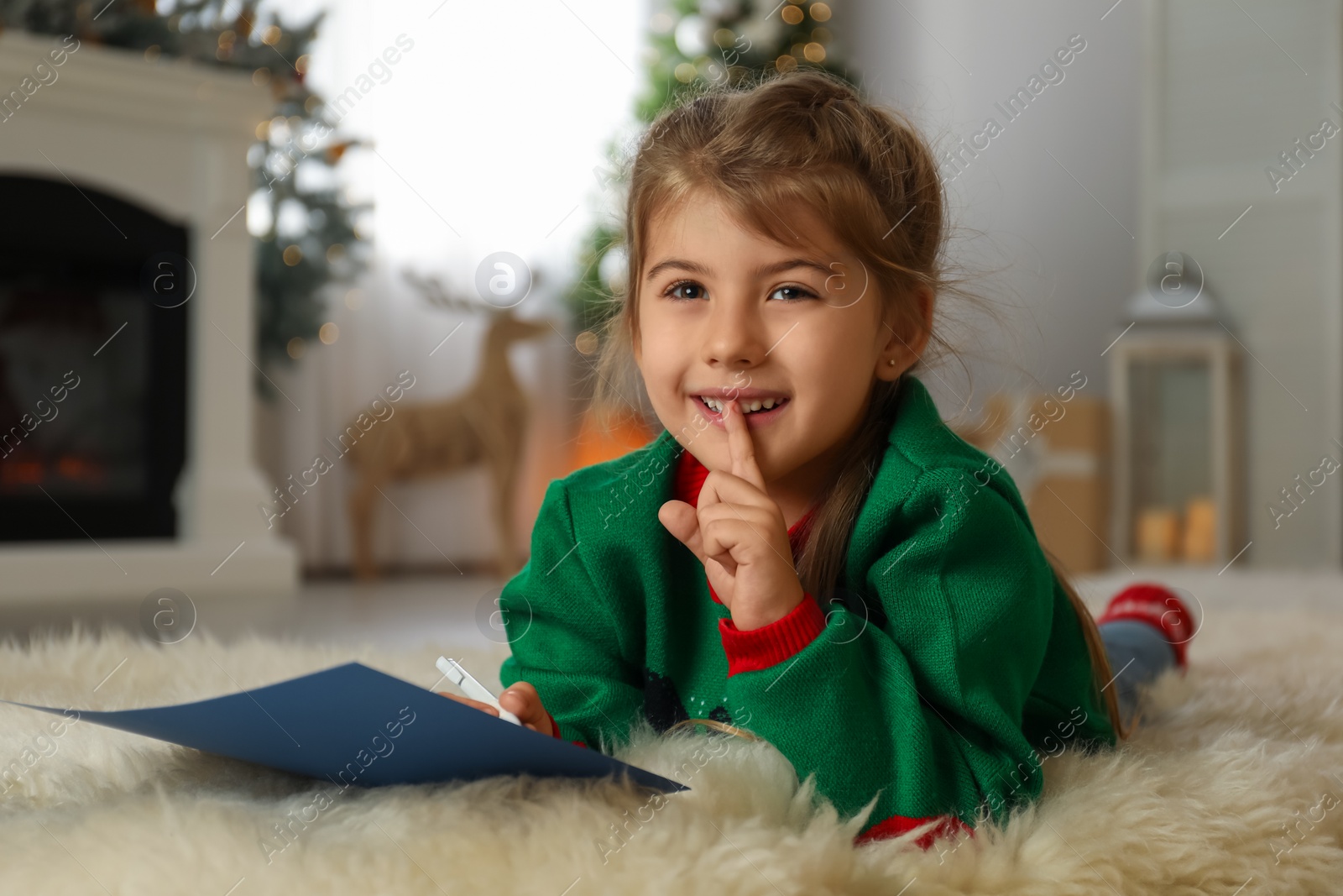 Photo of Cute child writing letter to Santa Claus at home. Christmas tradition