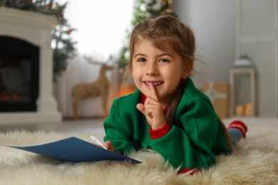 Cute child writing letter to Santa Claus at home. Christmas tradition