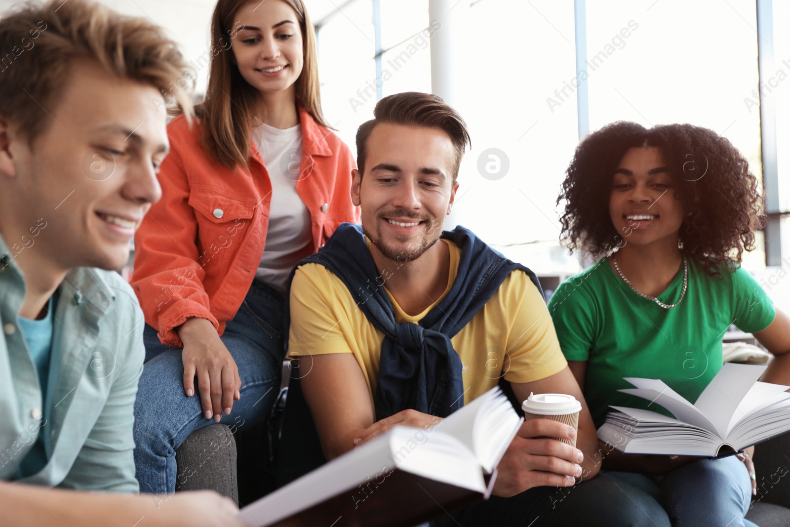 Photo of Group of young people studying at table in library