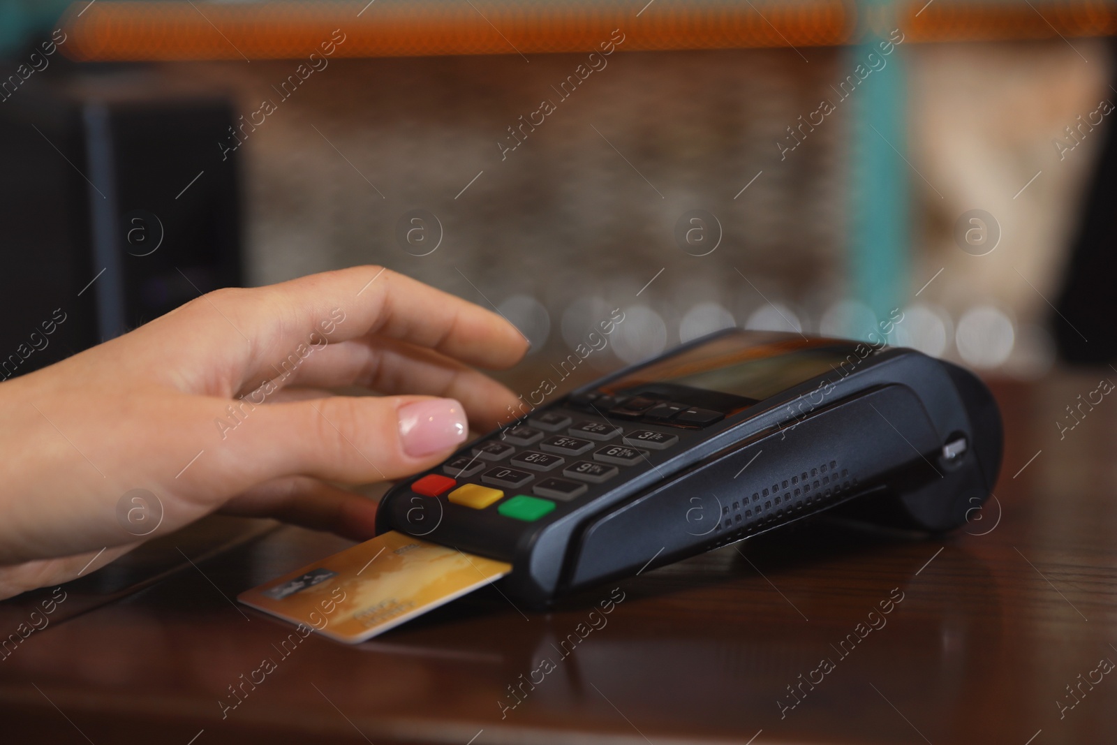 Photo of Woman using credit card machine for non cash payment in cafe, closeup