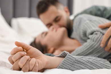 Photo of Affectionate young couple spending time together on bed, selective focus
