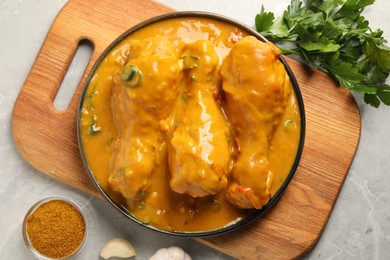 Tasty chicken curry and ingredients on grey textured table, flat lay