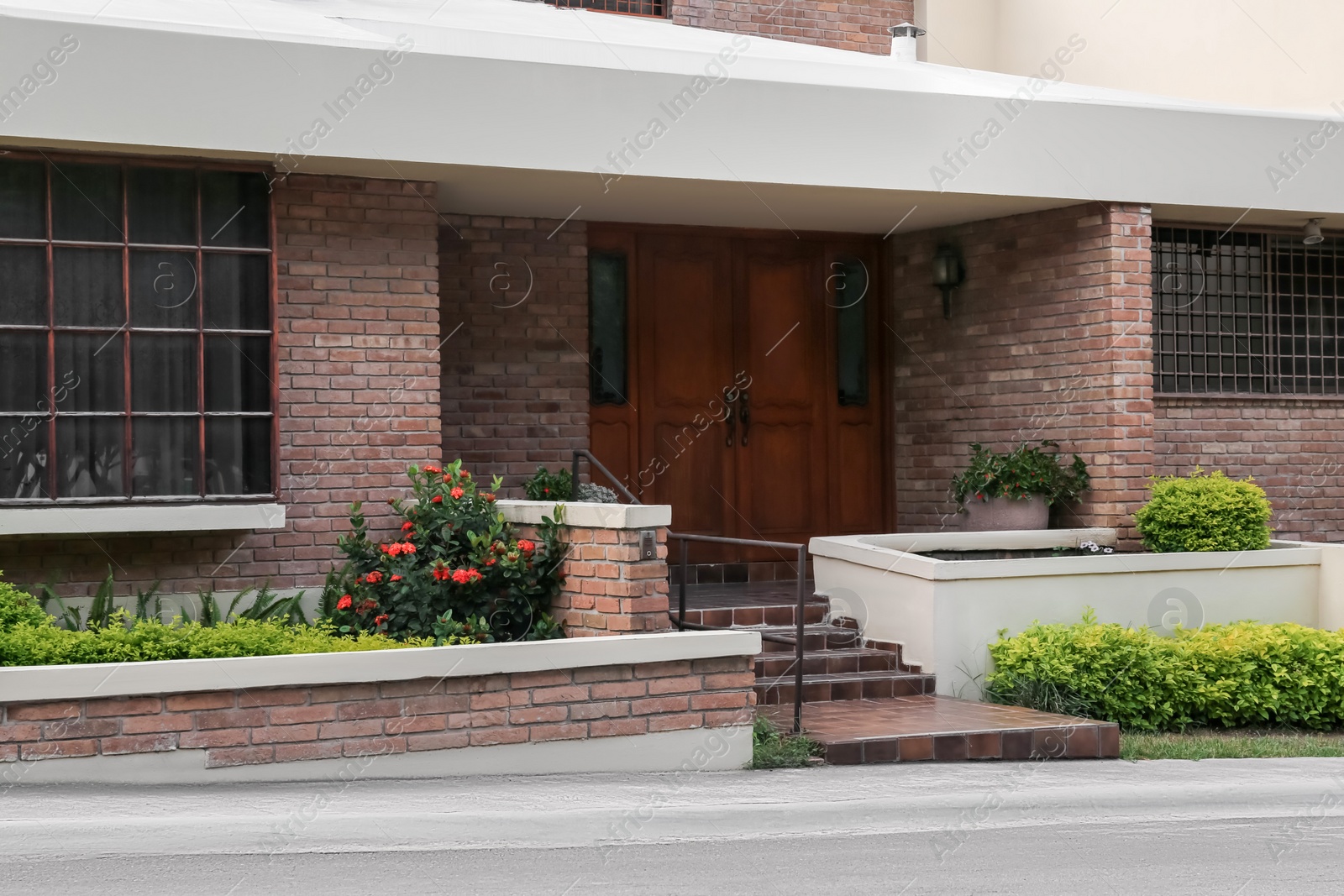 Photo of Entrance of beautiful residential building with wooden door on sunny day