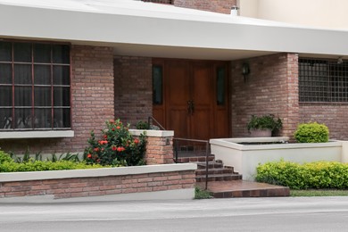 Entrance of beautiful residential building with wooden door on sunny day