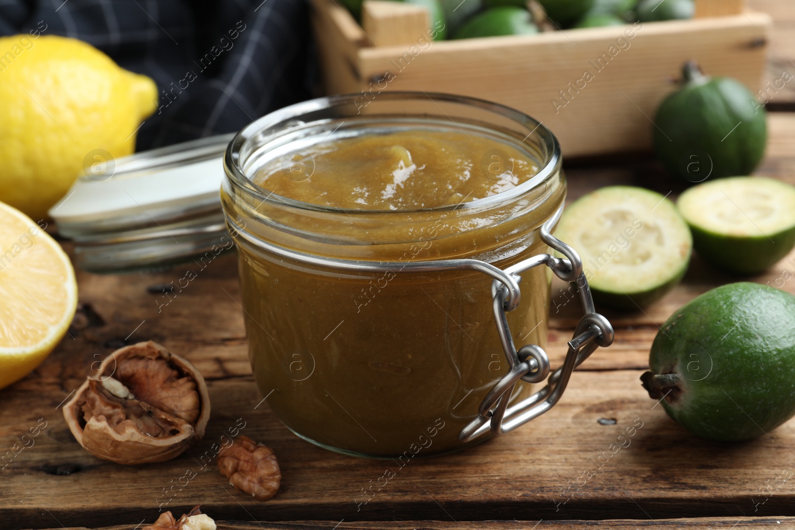 Photo of Feijoa jam in glass jar on wooden table, closeup