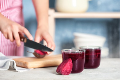 Glasses of beet smoothies and blurred woman on background