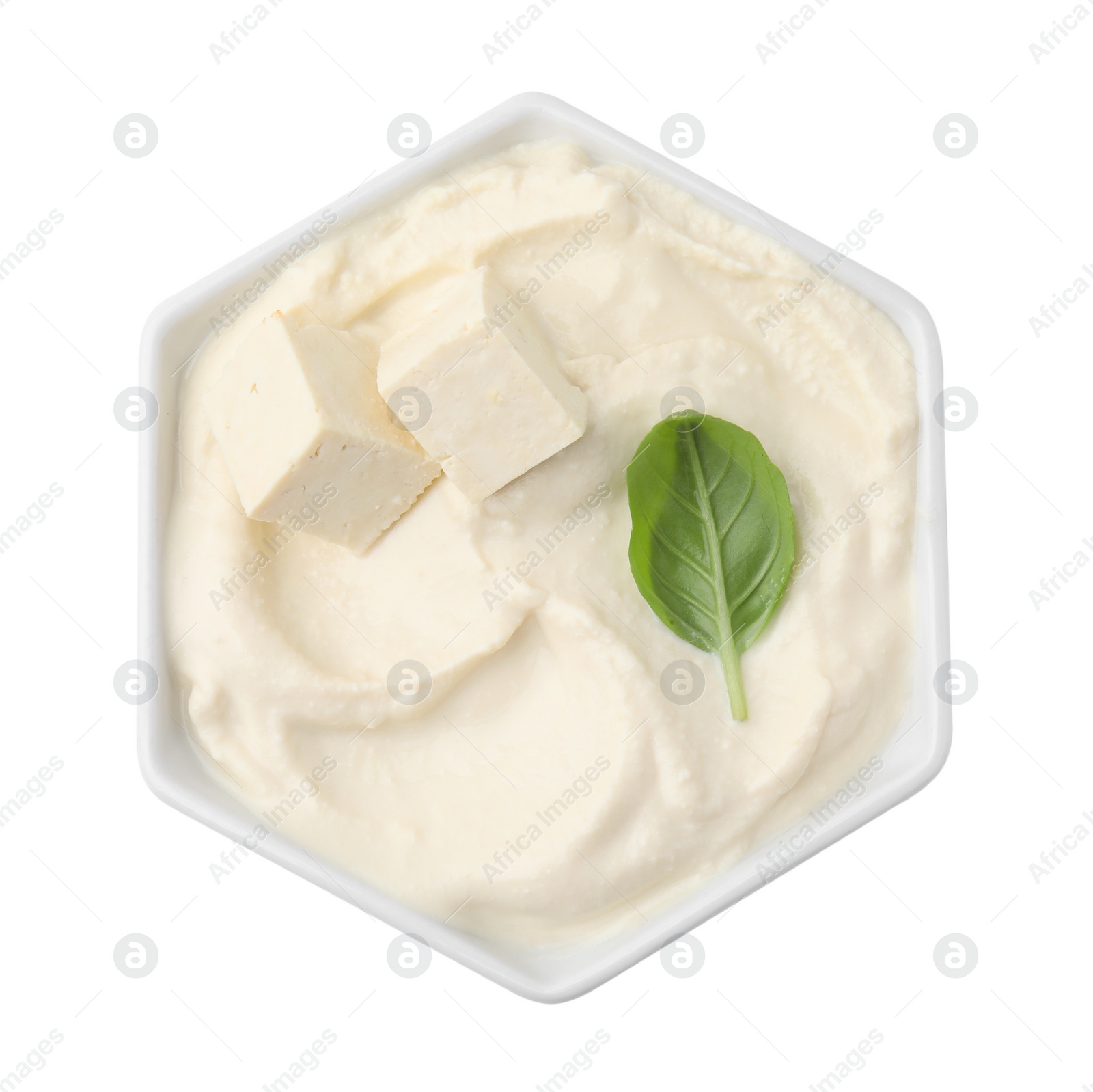Photo of Delicious tofu sauce and basil leaf in bowl isolated on white, top view