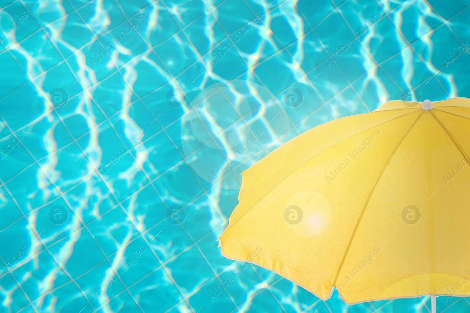 Image of Open beach umbrella and swimming pool. Summer vacation