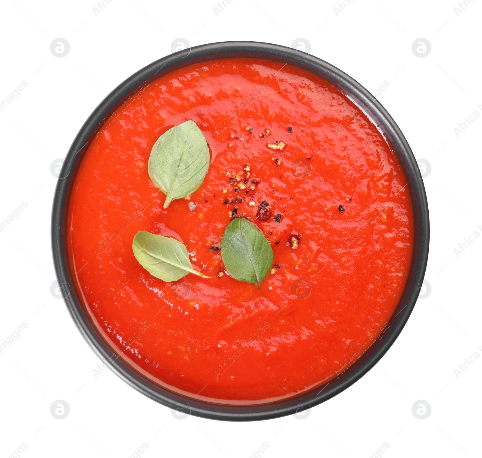 Photo of Bowl of delicious tomato cream soup isolated on white, top view