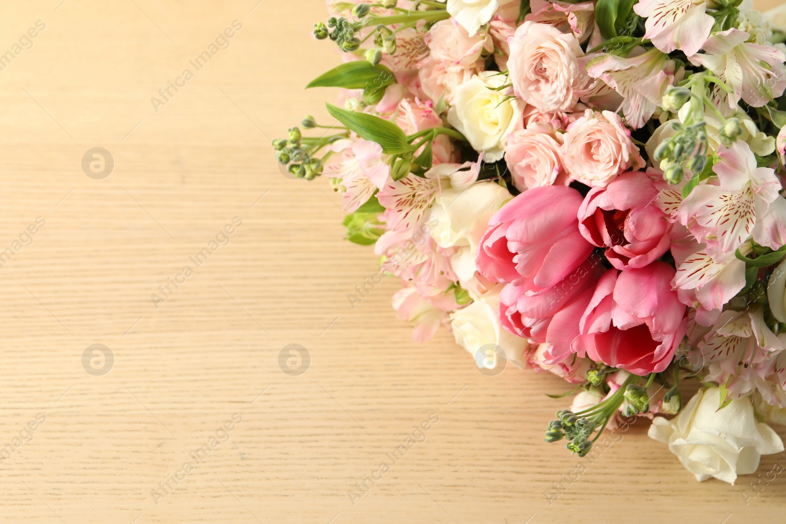 Photo of Beautiful bouquet of fresh flowers on wooden table, closeup. Space for text