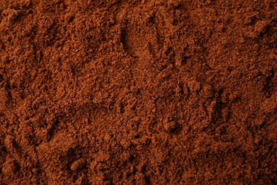 Photo of Heap of nutmeg powder as background, top view