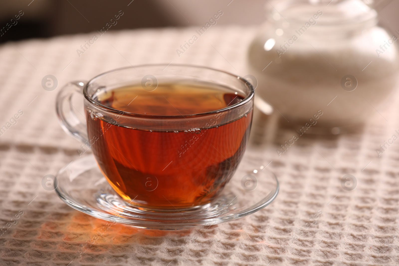 Photo of Aromatic tea in cup on table, closeup