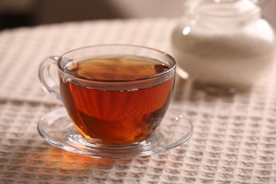 Photo of Aromatic tea in cup on table, closeup