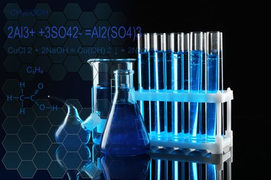 Laboratory glassware with blue liquids on black background