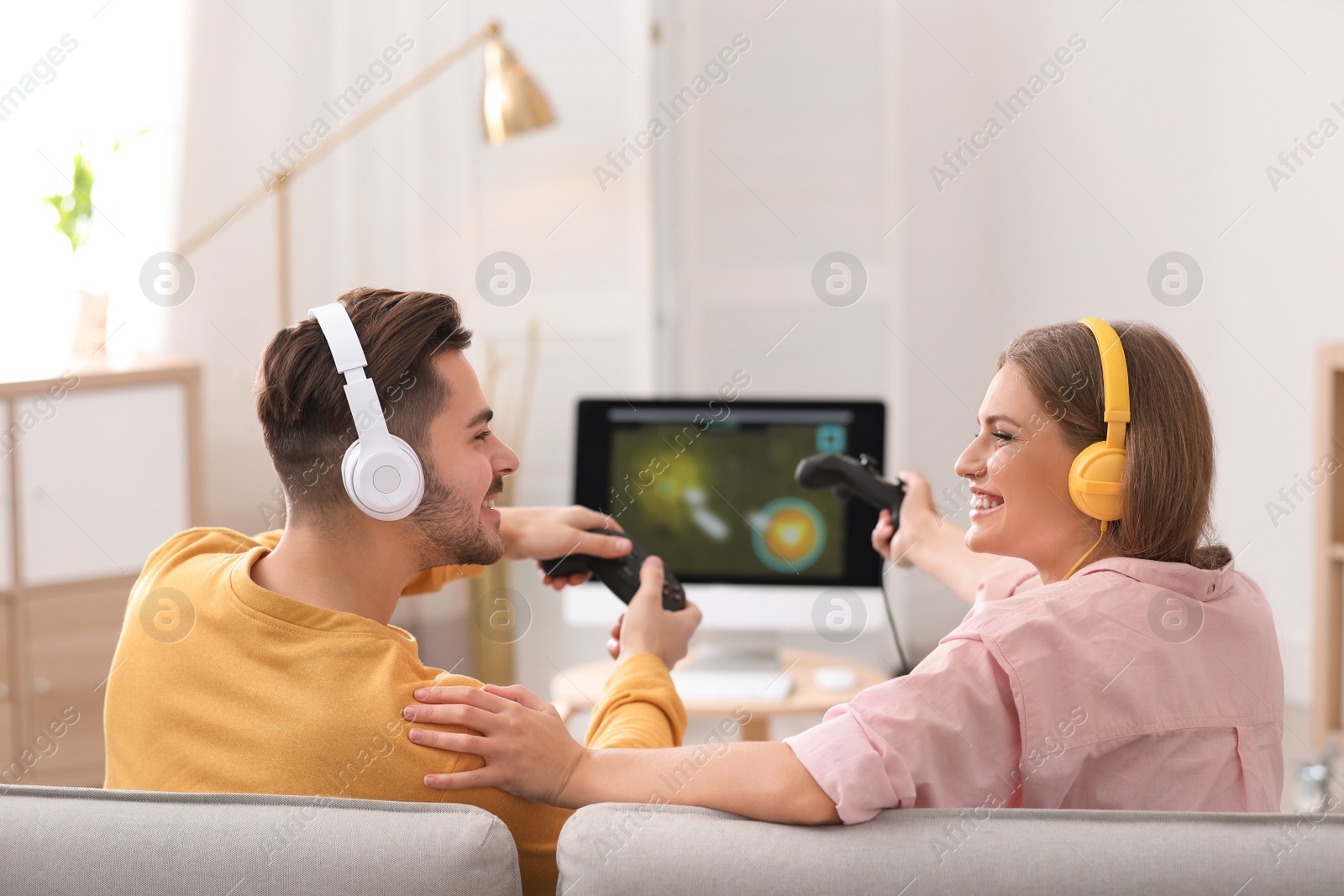 Photo of Emotional young couple playing video games at home