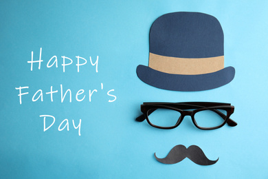 Eyeglasses, paper mustache and hat on light blue background, flat lay. Happy father's day