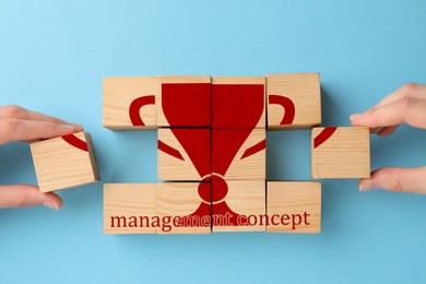 Image of Top view of people and wooden cubes with image of cup on light blue background
