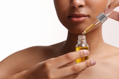 Photo of Woman with bottle of serum and dropper on white background, closeup