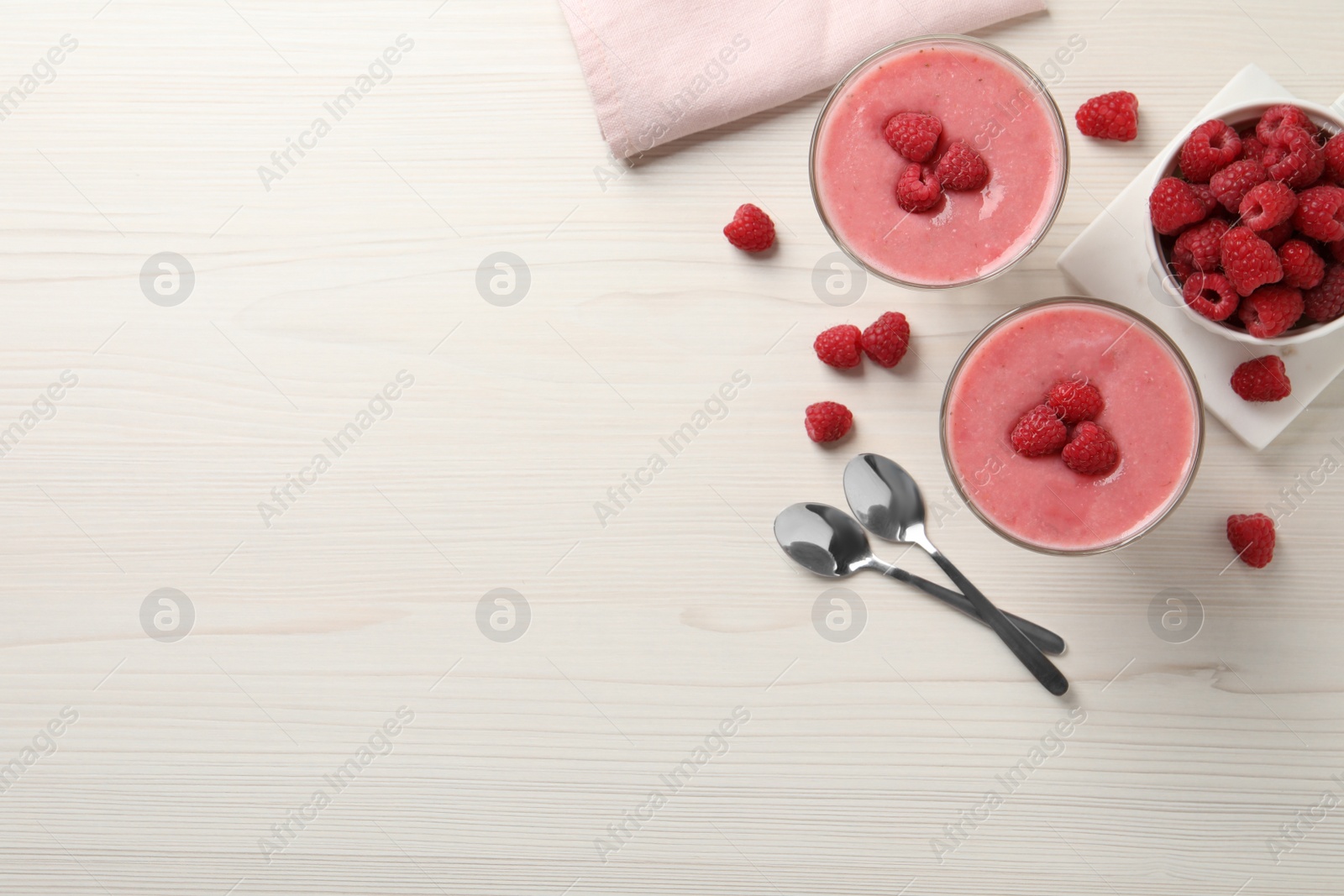 Photo of Delicious raspberry mousse on white wooden table, flat lay. Space for text