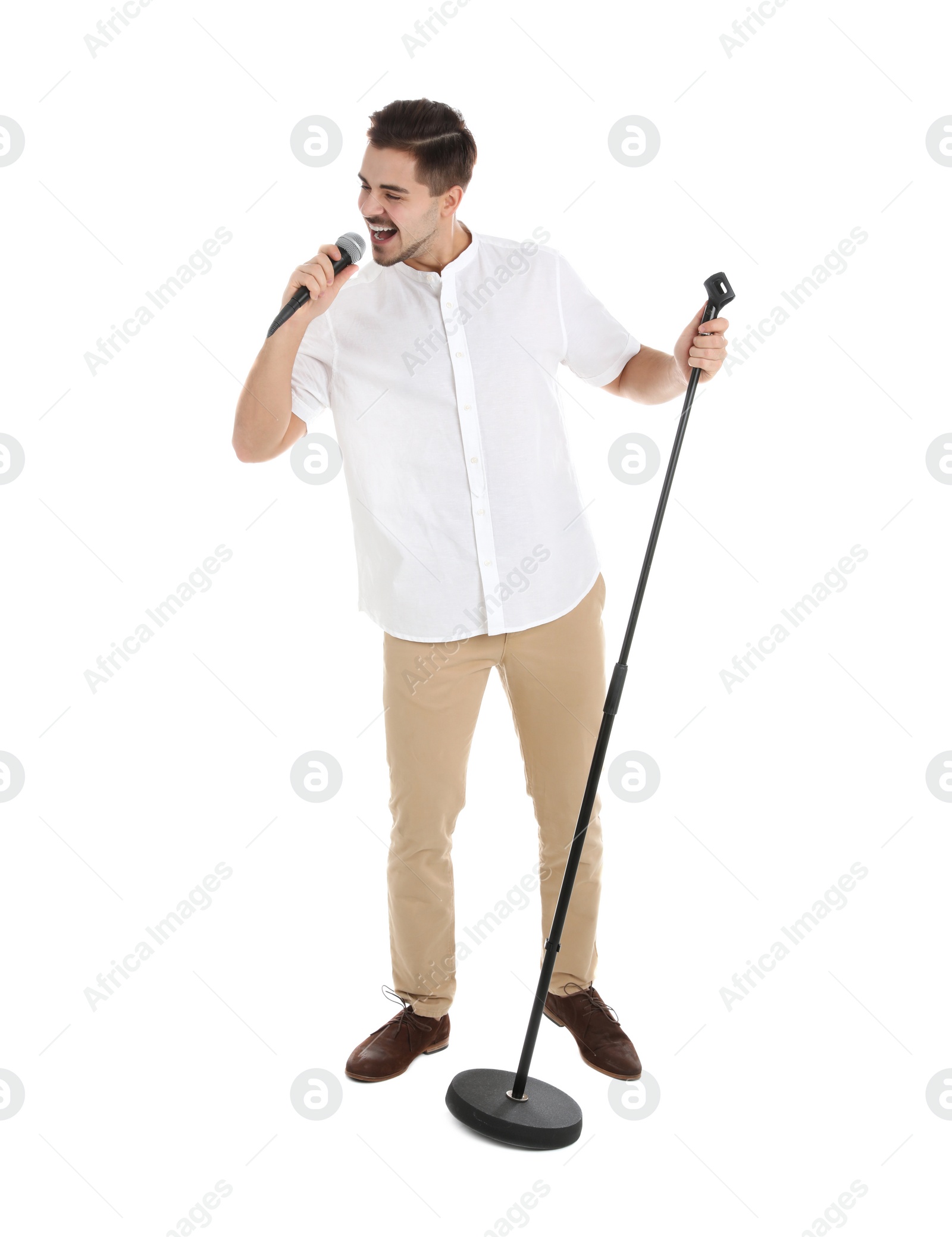 Photo of Young handsome man singing in microphone on white background