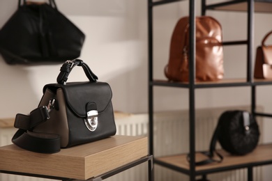 Photo of Elegant black bag on table in luxury boutique