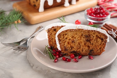 Photo of Traditional classic Christmas cake decorated with cranberries, pomegranate seeds and rosemary on light table