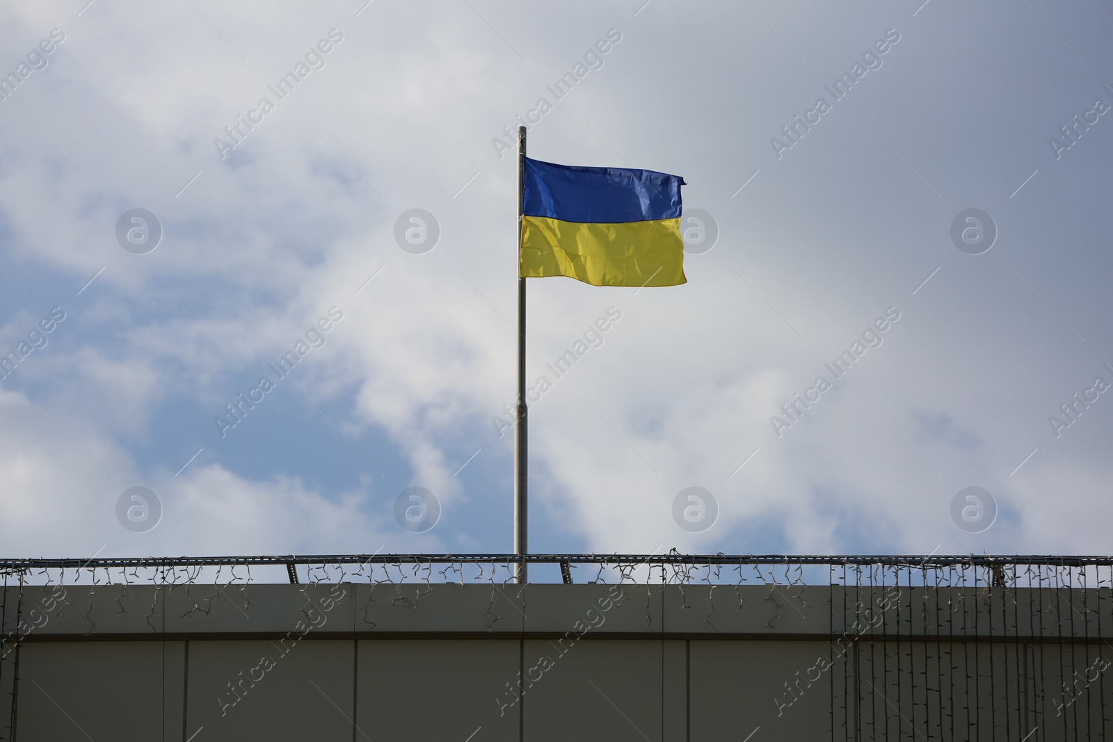 Photo of Ukrainian flag on building against cloudy sky