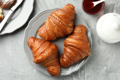 Flat lay composition with tasty croissants served on light grey textured table