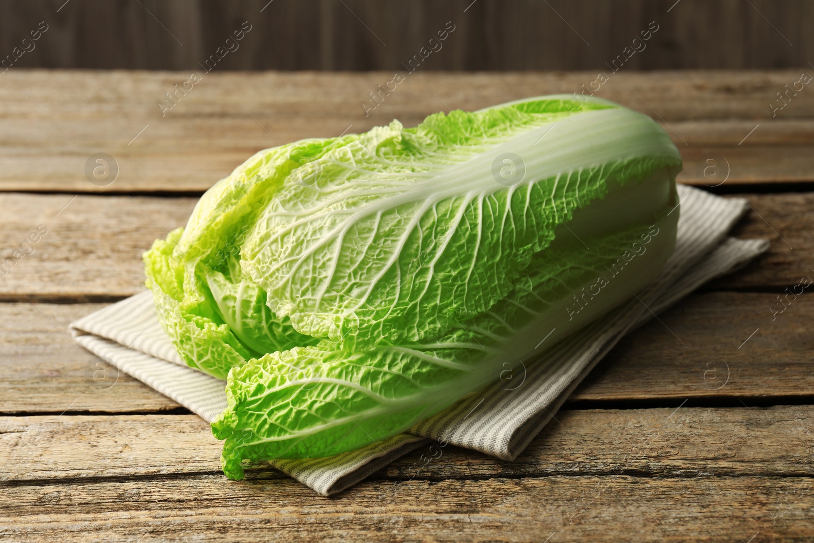 Photo of Fresh ripe Chinese cabbage on wooden table, closeup