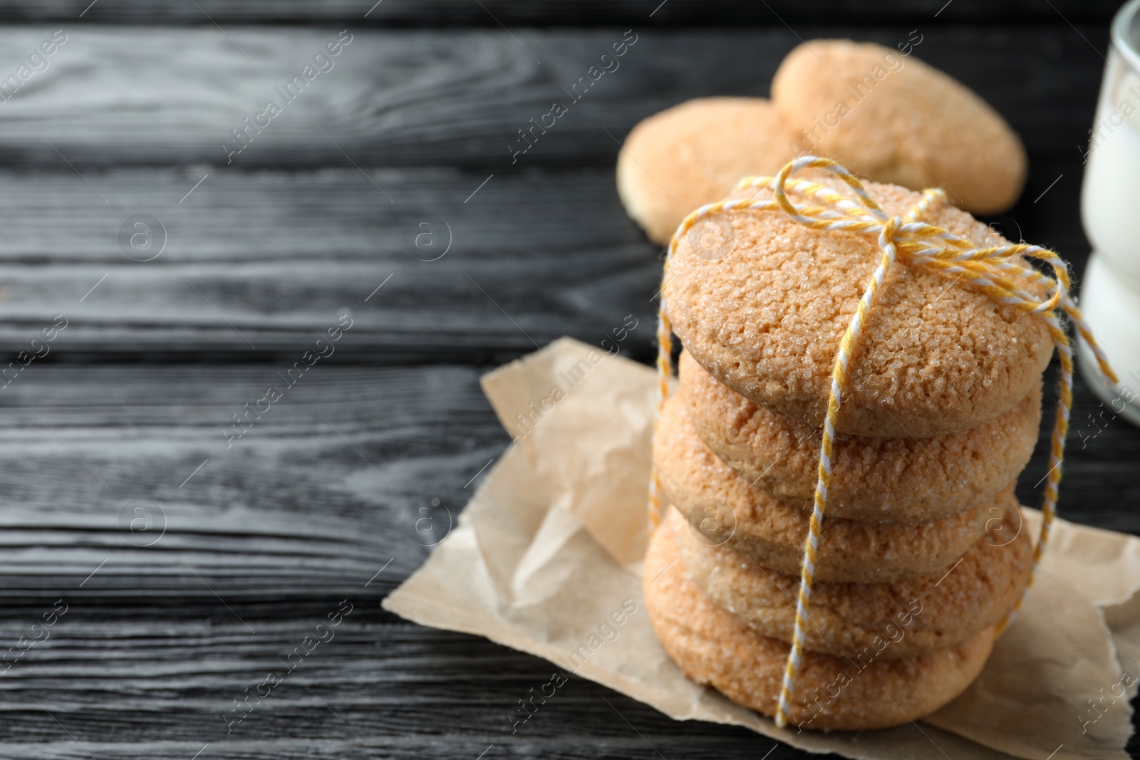 Photo of Delicious sugar cookies on black wooden table, closeup. Space for text