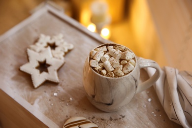Photo of Tasty hot drink with marshmallows and cookies on wooden table