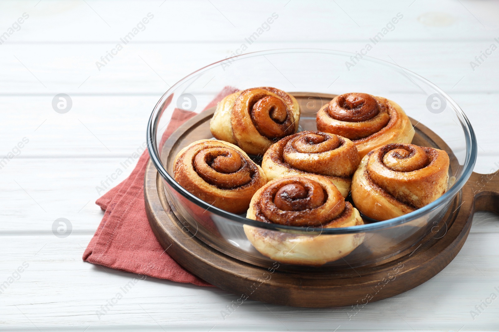 Photo of Tasty cinnamon rolls on white wooden table